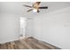 Wood-look flooring, a ceiling fan and a door to a bathroom are featured in this bedroom at 5911 63Rd N Ter, Pinellas Park, FL 33781