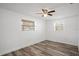 Bright bedroom with wood-look flooring, ceiling fan and natural light from two windows at 5911 63Rd N Ter, Pinellas Park, FL 33781