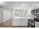 Modern kitchen with stainless steel appliances, white cabinetry and open plan living at 5911 63Rd N Ter, Pinellas Park, FL 33781