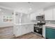 Stylish modern kitchen with white cabinetry, stainless steel appliances, and open plan living at 5911 63Rd N Ter, Pinellas Park, FL 33781