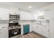 Bright kitchen features stainless steel appliances, gray backsplash, and white cabinetry at 5911 63Rd N Ter, Pinellas Park, FL 33781