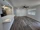 Open-concept living room with hardwood floors flowing into a modern kitchen with stainless steel appliances and marble countertops at 5911 63Rd N Ter, Pinellas Park, FL 33781