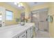 Well-lit bathroom with a large vanity, a framed mirror, and a glass-enclosed shower at 601 N Hercules Ave # 101, Clearwater, FL 33765