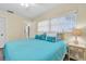 Bedroom featuring a cozy bed with bright blue quilt and ample natural light at 601 N Hercules Ave # 101, Clearwater, FL 33765