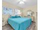 Sunny bedroom featuring a bright blue quilt, a ceiling fan, and a large window at 601 N Hercules Ave # 101, Clearwater, FL 33765