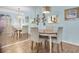 Light blue dining room featuring decorative lighting, a round dining table, and mirrored wall at 601 N Hercules Ave # 101, Clearwater, FL 33765
