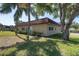 Charming home with a red tile roof, green grass, and mature trees providing shade at 601 N Hercules Ave # 101, Clearwater, FL 33765