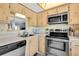 Compact kitchen featuring stainless steel appliances, wood cabinets, and a window view at 601 N Hercules Ave # 101, Clearwater, FL 33765