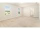 Bright, carpeted bedroom with natural light, two windows and a doorway to a closet at 6967 Silverado Ranch Blvd, Zephyrhills, FL 33541