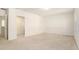 Spacious bedroom with neutral carpet and white walls, featuring a doorway to another room at 6967 Silverado Ranch Blvd, Zephyrhills, FL 33541