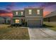 Charming two-story home with a two car garage during a colorful sunset at 6967 Silverado Ranch Blvd, Zephyrhills, FL 33541