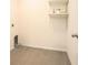 A clean utility room with gray tile floors and white walls, featuring built-in shelving at 6967 Silverado Ranch Blvd, Zephyrhills, FL 33541