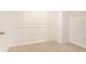 Neutral carpeted walk-in closet with built-in wire shelving and decorative wall accents at 6967 Silverado Ranch Blvd, Zephyrhills, FL 33541