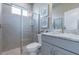 This bathroom features a glass-enclosed shower, gray vanity with marble countertop, and modern fixtures at 712 Estates Blvd, Tarpon Springs, FL 34689