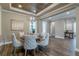 Elegant dining room featuring a wood tray ceiling, an eye-catching chandelier, and wood-look flooring at 712 Estates Blvd, Tarpon Springs, FL 34689