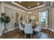 Stylish dining room with a wood-look floor, modern chandelier, and decorative mirror at 712 Estates Blvd, Tarpon Springs, FL 34689
