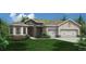 Charming single-Gathering home featuring a stone facade, two-car garage and a well manicured green lawn at 712 Estates Blvd, Tarpon Springs, FL 34689