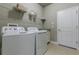 Well-lit laundry room features modern washer and dryer with overhead shelving, plus a built-in sink area at 712 Estates Blvd, Tarpon Springs, FL 34689