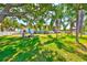 Expansive backyard with lush lawn, shade trees, outdoor seating, and a charming waterfront view at 732 Kingston Ct, Apollo Beach, FL 33572
