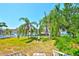 Scenic backyard view with lush palms, waterfront access, personal bench, and serene blue water at 732 Kingston Ct, Apollo Beach, FL 33572