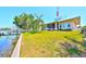 Lush backyard with waterfront access, a well-manicured lawn, and beautiful screened-in patio views at 732 Kingston Ct, Apollo Beach, FL 33572