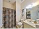 Cozy bathroom with shower, toilet, modern vanity, light fixtures, and decorative seahorse art at 732 Kingston Ct, Apollo Beach, FL 33572