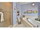 Relaxing bathroom showcasing a soaking tub, tiled shower, and decorative niches with art and accessories at 732 Kingston Ct, Apollo Beach, FL 33572