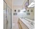 Bright bathroom with double sinks, a long vanity, tile floors and a glass shower door at 732 Kingston Ct, Apollo Beach, FL 33572