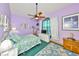 A vibrant bedroom features a ceiling fan, a side table and dresser for storage, and bright carpet at 732 Kingston Ct, Apollo Beach, FL 33572