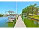 A boat is docked on a private wooden dock, offering direct access to the water and scenic waterfront views at 732 Kingston Ct, Apollo Beach, FL 33572