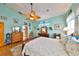 Bright main bedroom offers a large window for natural light, a decorative ceiling fan, and hardwood floors at 732 Kingston Ct, Apollo Beach, FL 33572