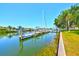 Waterfront home featuring a personal dock, clear canal views, lush greenery, and sunny skies at 732 Kingston Ct, Apollo Beach, FL 33572