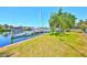 Lush waterfront property with a private dock, calm water, and vibrant green lawn with mature palms at 732 Kingston Ct, Apollo Beach, FL 33572
