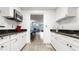 A kitchenette with white cabinets, dark countertops, and appliances at 7321 Central Ave # 503, St Petersburg, FL 33710
