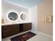 Modern bathroom with double sinks, lighted mirrors, dark wood cabinets, and a patterned rug at 777 3Rd Ave N # 1403, St Petersburg, FL 33701