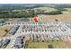 Wide aerial view showcases a community, with an arrow pointing to a listing, surrounded by greenery and amenities at 7797 Peace Lily Ave, Wesley Chapel, FL 33545
