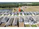 Aerial view of colorful homes in neighborhood with pond and trees in background at 7797 Peace Lily Ave, Wesley Chapel, FL 33545