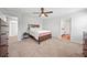 Bedroom featuring neutral colors, a wood bedframe, carpet, and attached bathroom and closet at 7797 Peace Lily Ave, Wesley Chapel, FL 33545