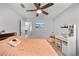 Bright bedroom featuring carpet flooring, a ceiling fan, television, and vanity at 7797 Peace Lily Ave, Wesley Chapel, FL 33545