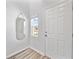 Clean bright entryway showcases a mirror, small window, and a white front door at 7797 Peace Lily Ave, Wesley Chapel, FL 33545