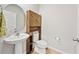 Half bathroom with pedestal sink, decorative cabinet, and modern fixtures at 7797 Peace Lily Ave, Wesley Chapel, FL 33545