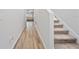 Bright hallway with wood-look flooring and carpeted stairs leading to the upper level at 7797 Peace Lily Ave, Wesley Chapel, FL 33545