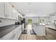 This modern kitchen overlooks the backyard and features a center island, white cabinets, and gray countertops at 7797 Peace Lily Ave, Wesley Chapel, FL 33545
