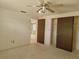Bedroom with ceiling fan, closet with sliding doors and view into the living area at 7812 Heather St, New Port Richey, FL 34653