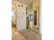 Hallway with views to the bath, kitchen and living room with carpeted floor and inset mirror at 7812 Heather St, New Port Richey, FL 34653