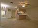 Open living space with a partial kitchen view, carpet flooring, and ample light at 7812 Heather St, New Port Richey, FL 34653
