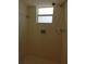 Tiled walk-in shower featuring a shower head, soap dish, and a small window at 7812 Heather St, New Port Richey, FL 34653