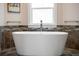 Bathroom featuring a freestanding soaking tub beneath a frosted privacy window at 826 Christina Cir, Oldsmar, FL 34677
