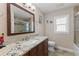Bright bathroom boasts granite vanity, framed mirror, tile flooring and shower with glass doors at 826 Christina Cir, Oldsmar, FL 34677