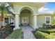 Inviting front entrance featuring an arched doorway with white columns and manicured landscaping at 826 Christina Cir, Oldsmar, FL 34677